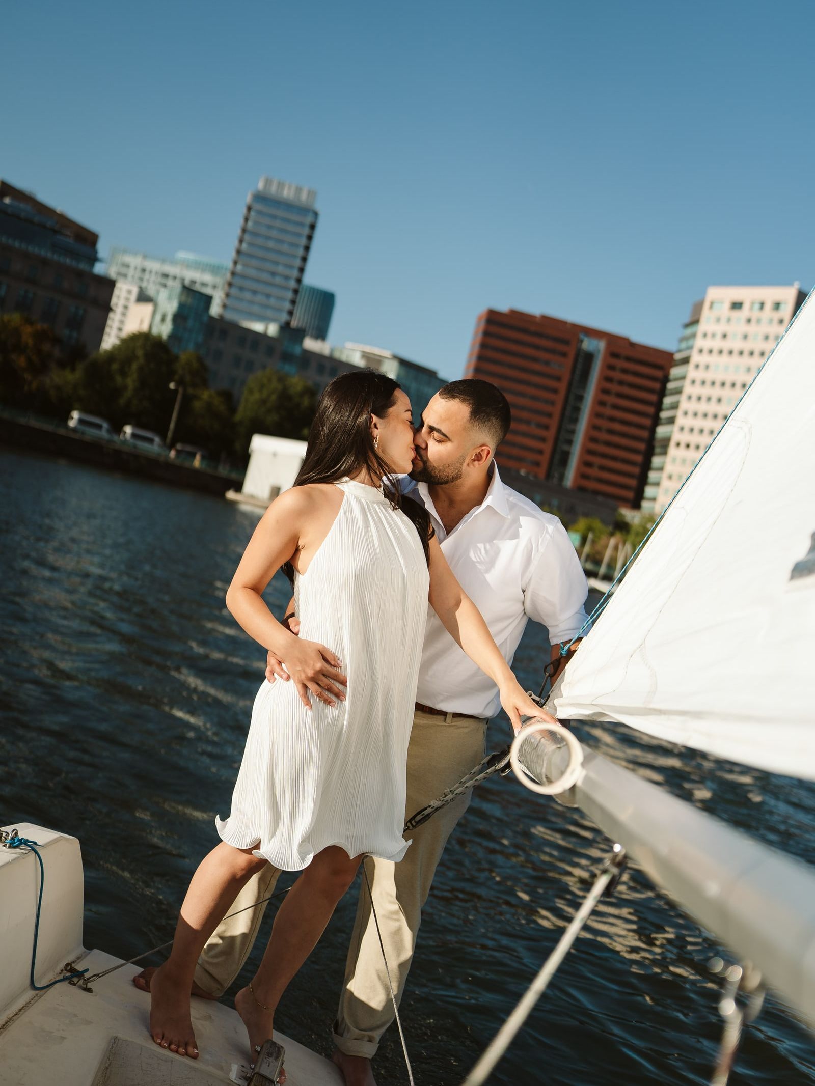 Doug and Julie on the bow of a sailboat, Boston skyline behind