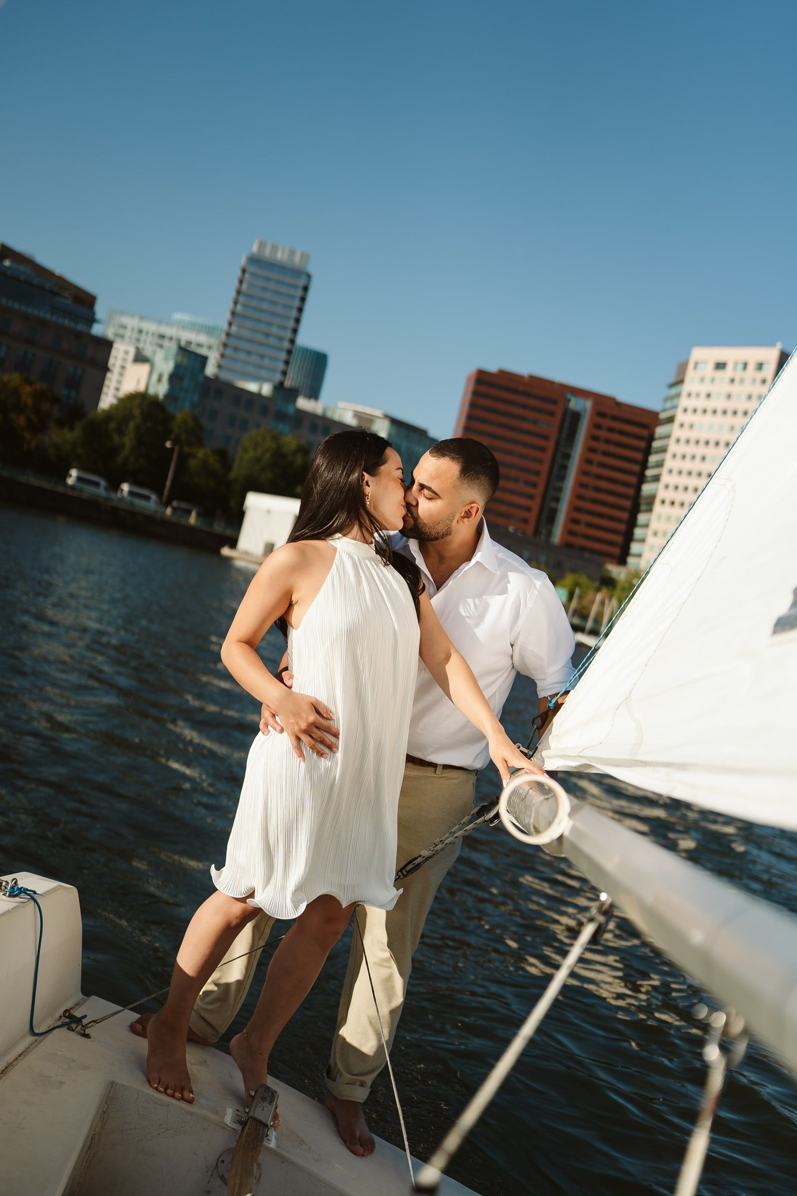 Doug and Julie on the bow of a sailboat, Boston skyline behind